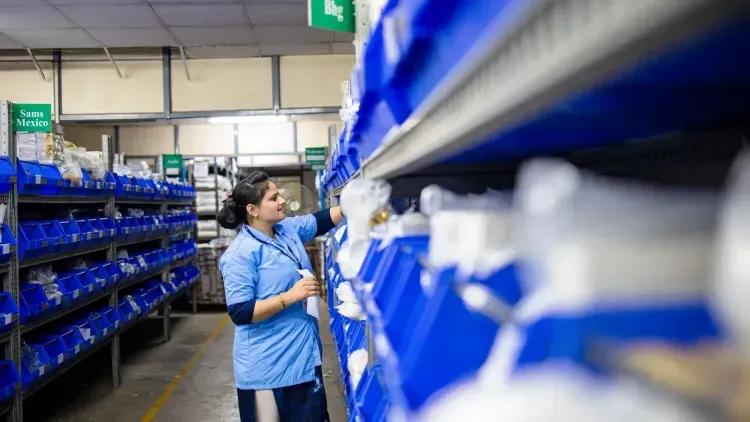 พนักงานจัดสินค้าในคลังที่มีป้ายกำกับชัดเจน / Warehouse worker organizing labeled inventory shelves