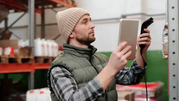 พนักงานใช้เครื่องสแกนบาร์โค้ดตรวจสอบสินค้าในคลัง / Warehouse worker scanning inventory barcodes